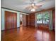 Spacious bedroom featuring wood paneling, hardwood floors, and a ceiling fan at 9272 Gotha Rd, Windermere, FL 34786