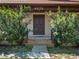 Inviting front entrance with a wooden door framed by lush greenery and steps, creating a warm welcome at 9272 Gotha Rd, Windermere, FL 34786