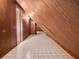 A naturally lit hallway with wooden paneled walls and neutral flooring, offering a unique architectural detail at 9272 Gotha Rd, Windermere, FL 34786