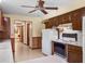 Functional kitchen with wood cabinetry, white appliances, and adjacent spaces at 9272 Gotha Rd, Windermere, FL 34786