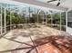 Enclosed patio with custom tiled area and view of the landscaped private backyard at 9700 Sw 194Th Cir, Dunnellon, FL 34432