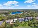 Aerial view of residential community with serene lake and well-manicured lawns, set amongst mature trees at 10148 Chiltern Garden Dr, Orlando, FL 32827