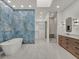 Bathroom boasts unique tile, a soaking tub, walk in shower, a modern vanity, and a walk-in closet at 10148 Chiltern Garden Dr, Orlando, FL 32827