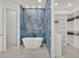 Modern bathroom features a soaking tub, stunning blue tile accent wall and a large closet at 10148 Chiltern Garden Dr, Orlando, FL 32827