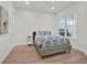 Cozy bedroom features a gray upholstered bed, wood-look floors and a view of the outdoors at 10148 Chiltern Garden Dr, Orlando, FL 32827