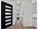 Bright entry hallway featuring sleek modern door, wood floors, and access to the bedroom at 10148 Chiltern Garden Dr, Orlando, FL 32827