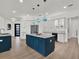 Bright, modern kitchen features a large blue island, white cabinets, stainless steel refrigerator, and wood-look tile floors at 10148 Chiltern Garden Dr, Orlando, FL 32827