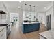 Modern kitchen showcasing a blue island, marble countertops, stainless steel appliances, and wooden flooring at 10148 Chiltern Garden Dr, Orlando, FL 32827