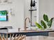 Close-up of kitchen island with sink, faucet, and marble countertop, complemented by plant and shelf decor at 10148 Chiltern Garden Dr, Orlando, FL 32827