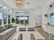 Bright living room with large windows, neutral sofa, patterned chairs, and views of the outdoor patio at 10148 Chiltern Garden Dr, Orlando, FL 32827