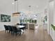Open-concept living and dining area with stylish furnishings, wood flooring, and sliding doors to the outdoor patio at 10148 Chiltern Garden Dr, Orlando, FL 32827