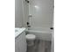 Modern bathroom with tiled shower, white vanity, black hardware, and gray vinyl floor at 1055 W French Ave, Orange City, FL 32763