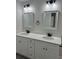 Bathroom featuring double vanity with white countertop, black fixtures, and two mirrors at 1055 W French Ave, Orange City, FL 32763
