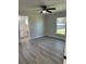 Bedroom with gray flooring, ceiling fan, and a view to the bathroom and the yard at 1055 W French Ave, Orange City, FL 32763