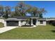 Charming single-story home featuring a well-manicured lawn, a two-car garage, and attractive stone accents on the facade at 1055 W French Ave, Orange City, FL 32763