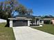 Charming single-story home featuring a large driveway, a two-car garage, and attractive stone accents on the facade at 1055 W French Ave, Orange City, FL 32763