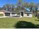 Charming single-story home featuring a well-manicured lawn, a two-car garage, and attractive stone accents on the facade at 1055 W French Ave, Orange City, FL 32763