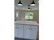 Kitchen with white cabinets, gray flooring and a large center island with white countertop at 1055 W French Ave, Orange City, FL 32763