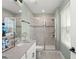 Bright bathroom featuring double vanity and a glass shower, enhancing the space with natural light and style at 11844 Pulitzer Pl, Orlando, FL 32832