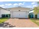 Two car garage with brick driveway and landscaped yard at 11844 Pulitzer Pl, Orlando, FL 32832