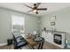 Well-lit office features modern ceiling fan, desk, and storage cabinet with stylish sliding doors at 11844 Pulitzer Pl, Orlando, FL 32832