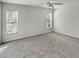 Spacious bedroom with neutral carpet, ceiling fan, and natural light from the two windows at 120 Mayfair Ct # 120, Sanford, FL 32771