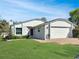 Charming one-story home featuring a red front door, brick pathway, well-manicured lawn, and attached two-car garage at 120 Mayfair Ct # 120, Sanford, FL 32771