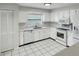 Bright kitchen features white cabinetry, appliances, and tile flooring, creating a clean and modern look at 120 Mayfair Ct # 120, Sanford, FL 32771