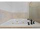 Close up of soaking tub with bronze fixtures and decorative tile at 1380 Normandy Heights Cir, Winter Haven, FL 33880