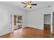 Bedroom with hardwood floors, ceiling fan and sliding doors to a screened in pool at 1380 Normandy Heights Cir, Winter Haven, FL 33880