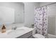 Well-lit bathroom with a white vanity, patterned shower curtain, and tiled walls at 1399 Lassen St, Haines City, FL 33844