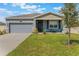 Charming single-story home with a well-maintained lawn and a cozy front porch seating area at 1399 Lassen St, Haines City, FL 33844