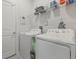 Functional laundry room with white washer and dryer, shelving, and ample storage space at 1399 Lassen St, Haines City, FL 33844