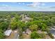 An aerial view shows the neighborhood's tree-lined streets and a home with a fenced yard at 1401 E Voorhis Ave, Deland, FL 32724