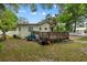Backyard view with a deck, mature trees, and partial fencing, providing outdoor space and privacy at 1401 E Voorhis Ave, Deland, FL 32724