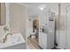 Bright bathroom/laundry room combo featuring new fixtures, storage and a washer/dryer at 1401 E Voorhis Ave, Deland, FL 32724