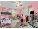 Playful pink bedroom featuring a bunk bed, plush rug, and toys at 1401 E Voorhis Ave, Deland, FL 32724