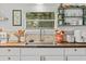 Bright kitchen featuring white cabinets, butcher block countertops, and a stylish backsplash detail at 1401 E Voorhis Ave, Deland, FL 32724