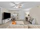 Bright living room featuring a ceiling fan, brick accent wall, and cozy seating area at 1401 E Voorhis Ave, Deland, FL 32724
