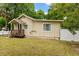 Rear exterior view of this charming home features a well-maintained lawn and partially fenced yard at 1401 E Voorhis Ave, Deland, FL 32724