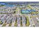 Aerial view of a vibrant community featuring well-maintained homes, tennis courts, and scenic water views at 14317 Lanikai Beach Dr, Orlando, FL 32827