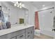 Bright bathroom with a gray vanity, stone countertop, and shower with a patterned curtain at 14317 Lanikai Beach Dr, Orlando, FL 32827
