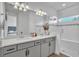 Bathroom features a dual sink vanity, framed mirror, and glass enclosed shower at 14317 Lanikai Beach Dr, Orlando, FL 32827