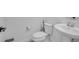 Well-lit half bathroom with modern toilet, elegant fixtures, and pedestal sink at 14317 Lanikai Beach Dr, Orlando, FL 32827