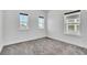 Empty bedroom with three windows, neutral walls, and plush gray carpeting at 14317 Lanikai Beach Dr, Orlando, FL 32827