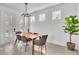 Charming dining area with modern table, elegant chandelier, and view of outdoor scenery at 14317 Lanikai Beach Dr, Orlando, FL 32827