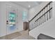 Bright entryway with decorative front door, staircase, and modern tiled floor at 14317 Lanikai Beach Dr, Orlando, FL 32827