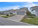 Home exterior featuring a two-car garage and landscaped front yard at 14317 Lanikai Beach Dr, Orlando, FL 32827