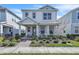 Charming two-story home with landscaped front yard and inviting covered porch with seating at 14317 Lanikai Beach Dr, Orlando, FL 32827