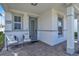 Inviting front porch features neutral chairs, brick flooring, and a blue front door at 14317 Lanikai Beach Dr, Orlando, FL 32827